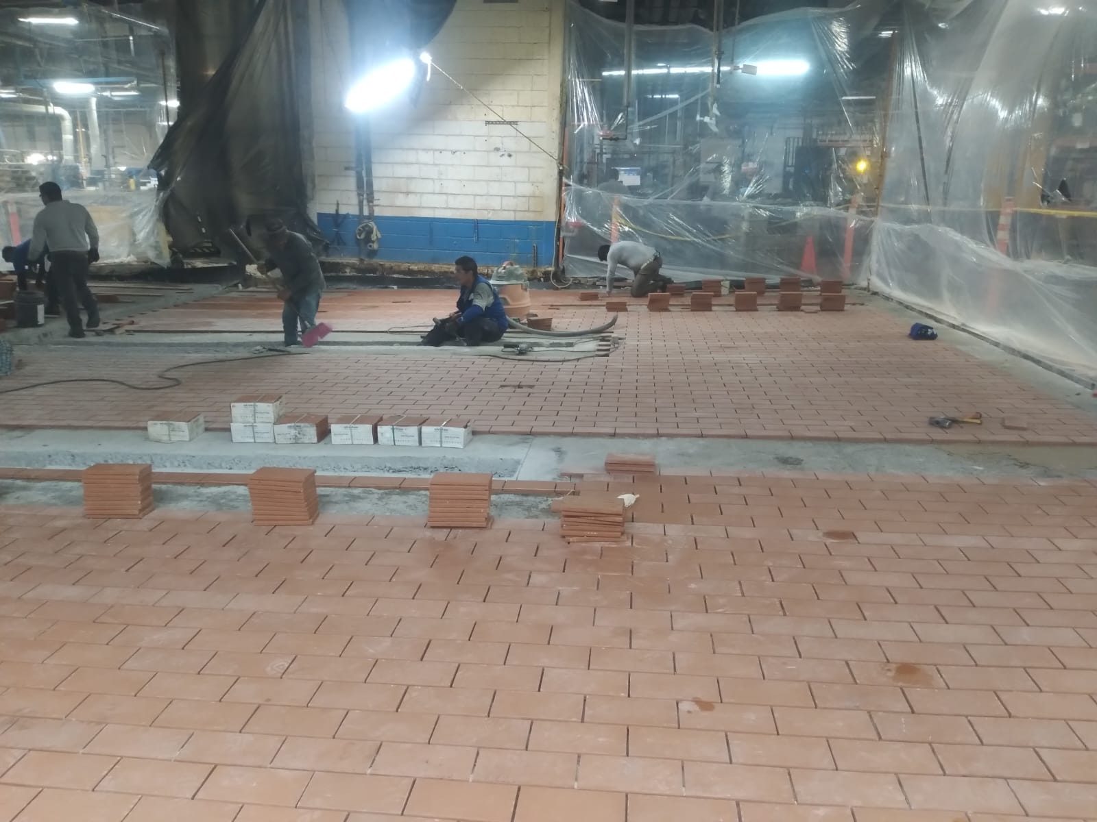 Cuadrilla de KERALITAS instalando loseta industrial en planta en operación